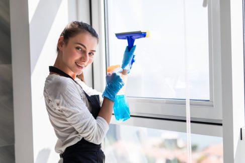 people-housework-housekeeping-concept-happy-woman-gloves-cleaning-window-with-rag-cleanser-spray-home-min
